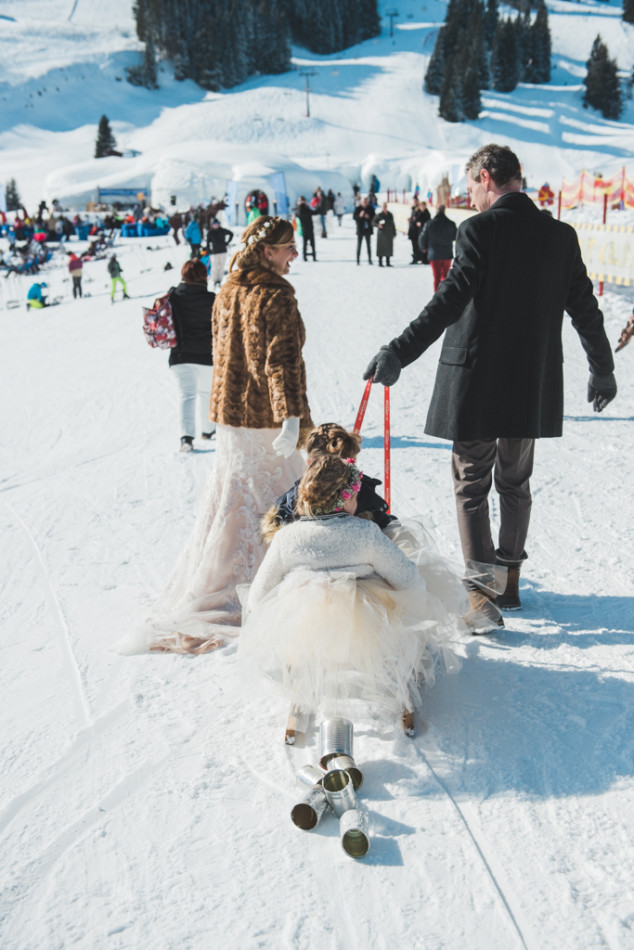 flower girl on a sleigh during a destination wedding in brixen im thale in austria