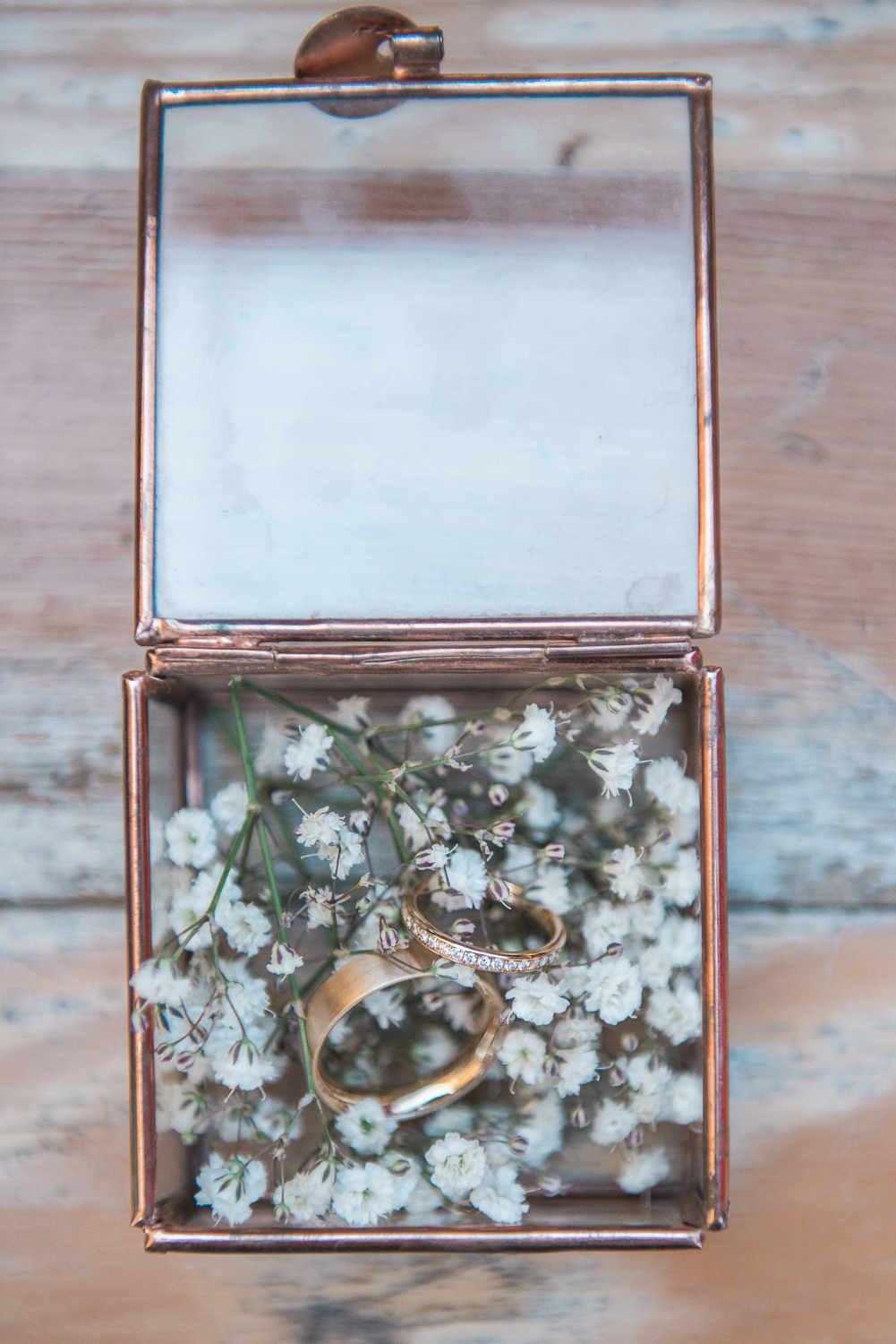 Gold wedding rings in a copper glass ring box