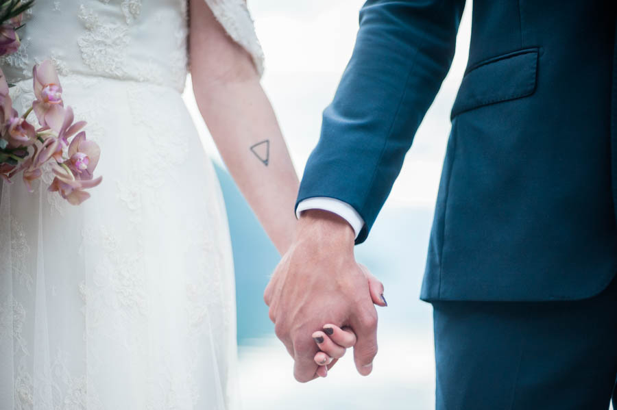 bride, wearing a sibo design dress, and groom holding hands in norway