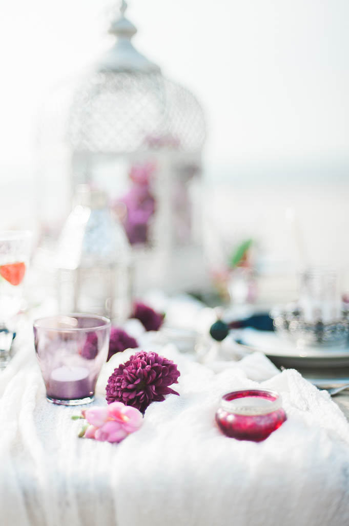 Table with a white table runner and purple accesories