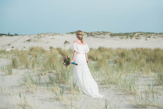 A bride wearing a Daughters of Simone dress in the dunes of The Netherlands