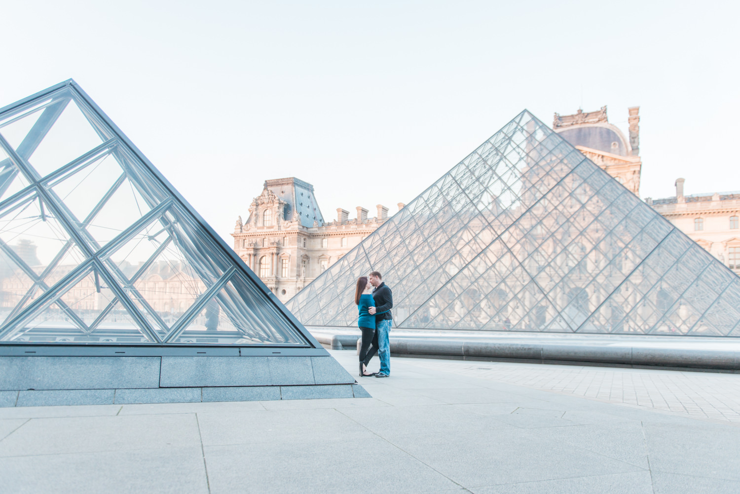 Couple on the square of the Louvre museum in Paris, captured by an English wedding photographer in France