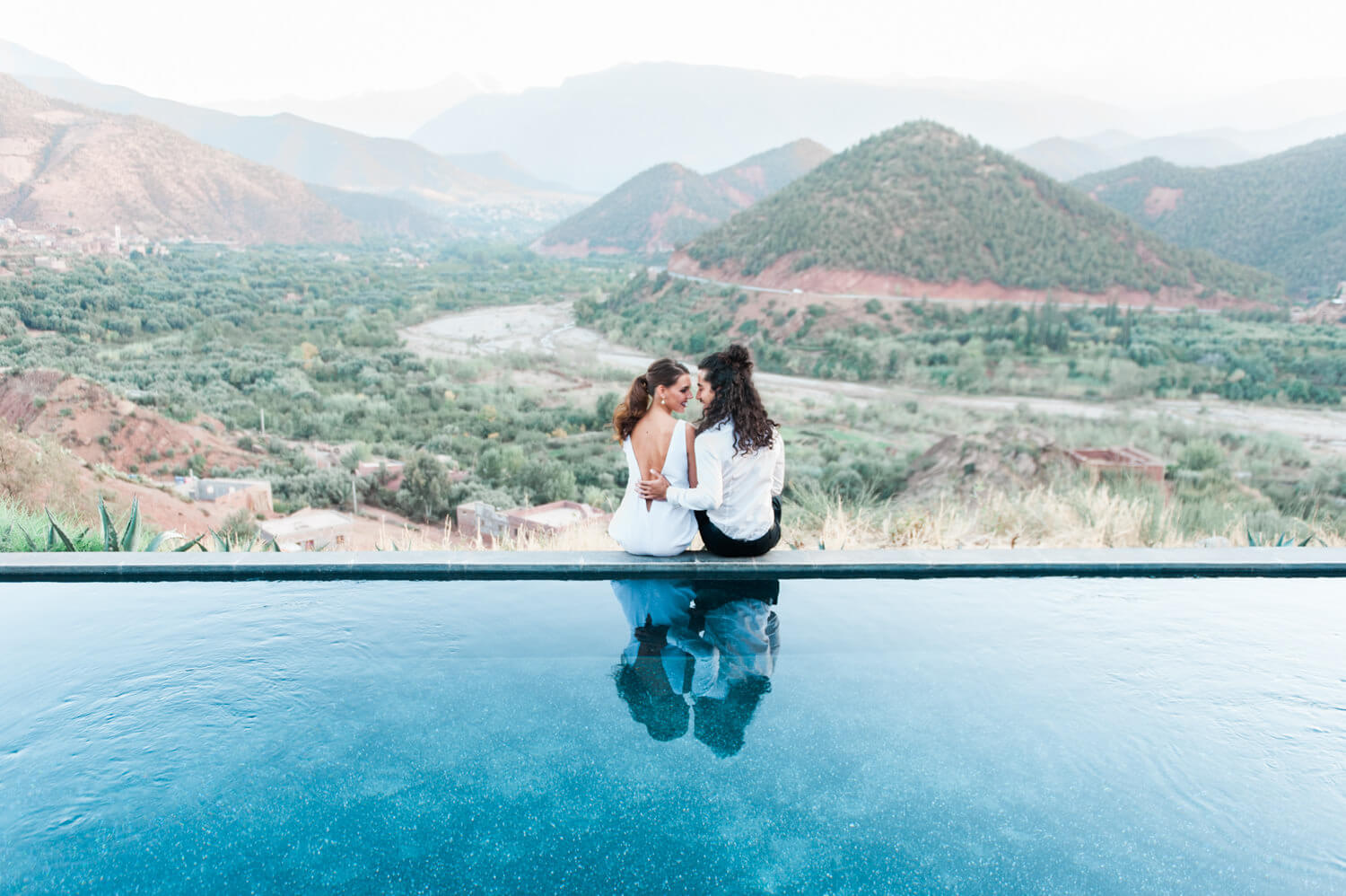 A bride and groom at Marrakech's Kasbah bab Ourika looking out over the Atlas Mountains in Morocco, captured by destination wedding photographer Wit Photography