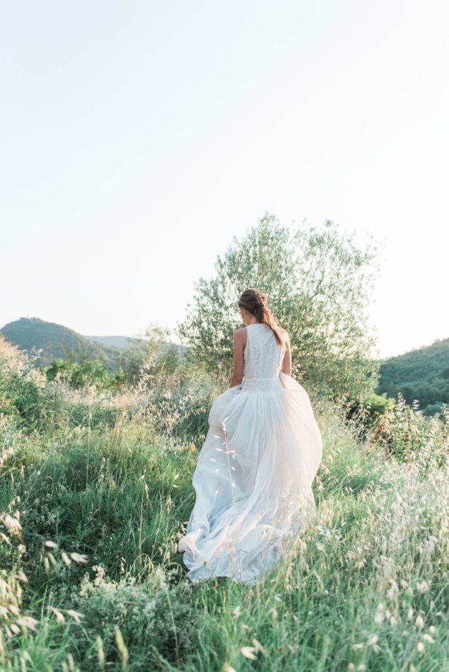 Bride in the holding hills of Tuscany, captured by a wedding photographer in Italy
