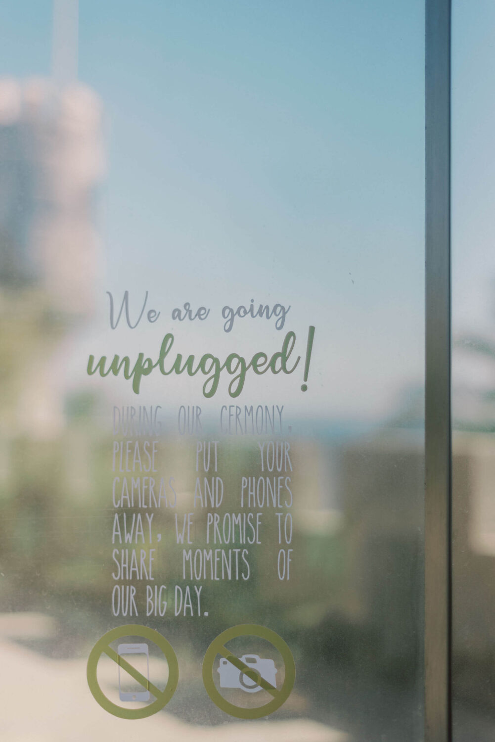 Glass door with a sign stating this is an unplugged wedding