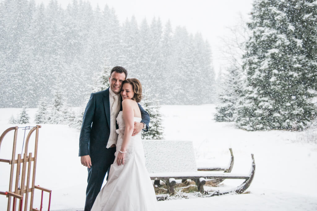 A bride and groom on snow filled wedding day in Europe