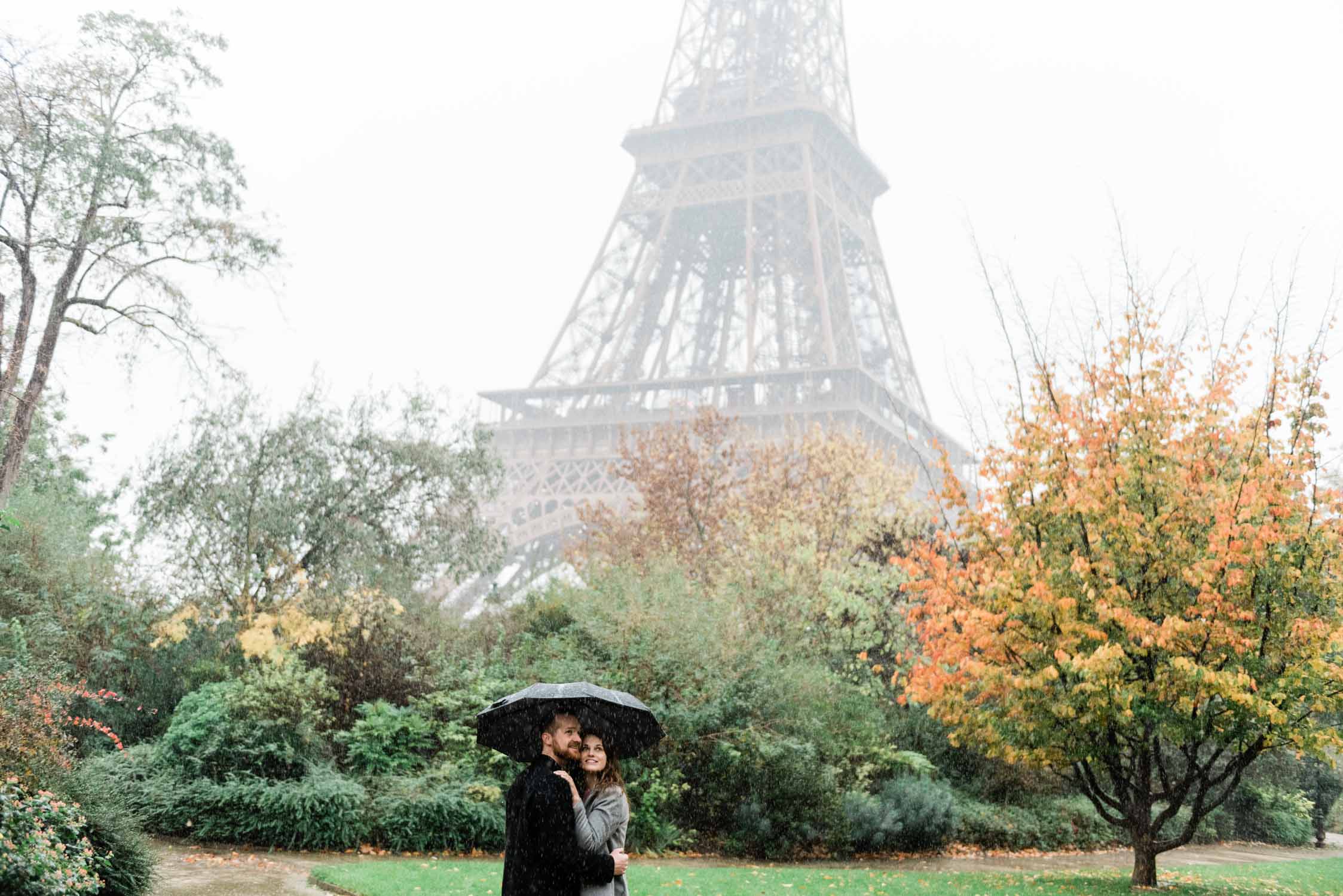 Newly engaged couple in front of the Eiffel tower and fall foliage