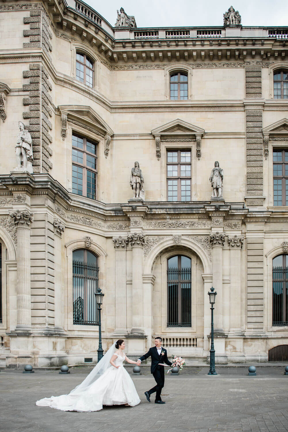 Elopement in Paris photography - a bride and groom run in the streets of Paris